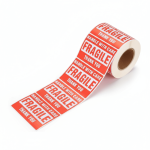 A roll of red **fragile sticker** labels with "Handle With Care" text, applied to a cardboard shipping box.