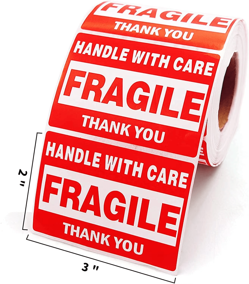 A roll of red **fragile sticker** labels with "Handle With Care" text, applied to a cardboard shipping box.