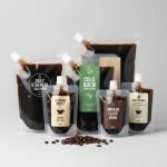 A custom printed frosted **cold brew spout pouch** standing upright, filled with dark coffee concentrate.