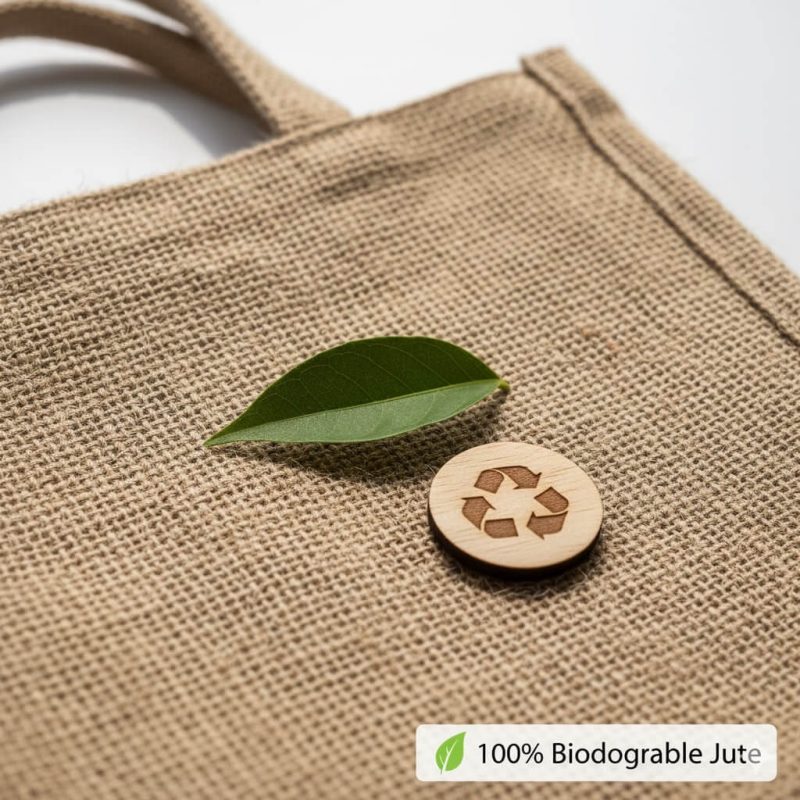 A natural brown **custom jute bag** with black logo printing and soft cotton handles, filled with fresh flowers.