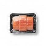 A roll of transparent **vacuum skin film** being used to package fresh salmon steaks on a VSP machine.