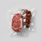 A clear, smooth commercial retort vacuum pouch containing a raw steak, ready for sous vide cooking or sterilization in a chamber sealer.