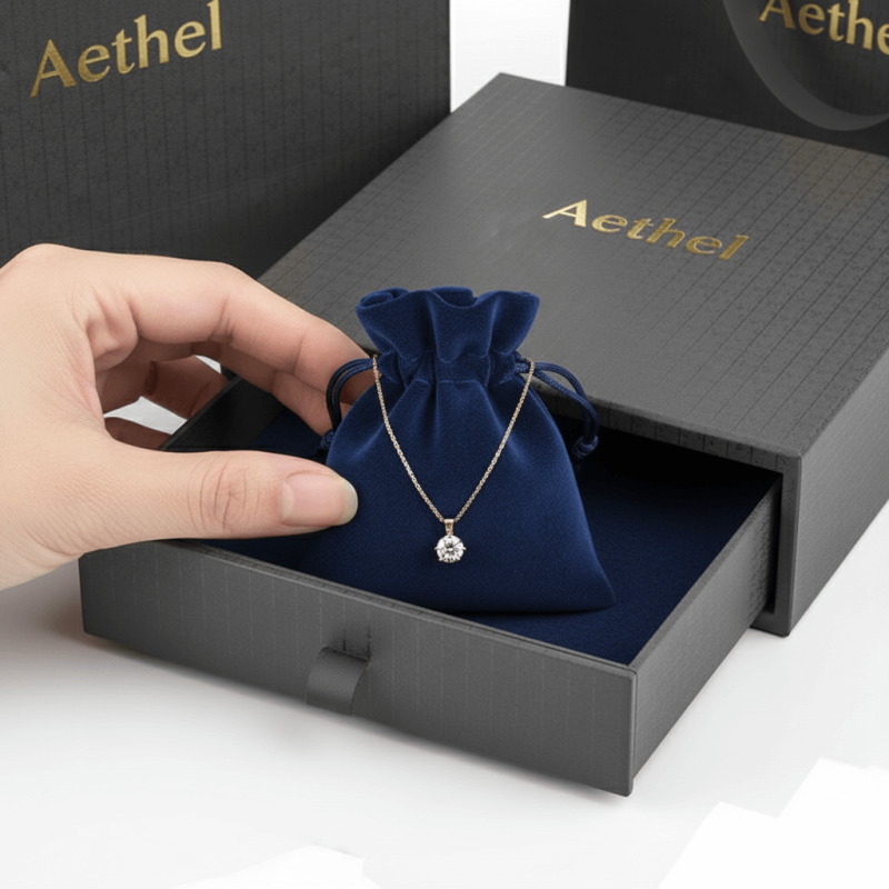 A custom printed rigid **jewelry drawer box** sliding open to reveal a soft velvet pouch inside for ring packaging.