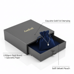 A custom printed rigid **jewelry drawer box** sliding open to reveal a soft velvet pouch inside for ring packaging.