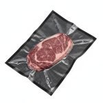 A premium **black vacuum sealer bags** pouch containing a fresh steak, showing the high-contrast black back and clear front.