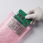 A pink anti-static bubble bag holding a green circuit board to show protection and clarity.