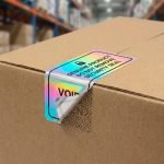 A custom die-cut holographic sticker showing a rainbow iridescent effect on a black package.