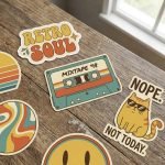 A group of custom die cut stickers with vibrant cartoon designs on a waterproof vinyl background.