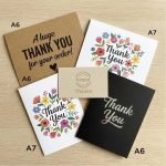 A group of personalized modern package insert cards with gold foil logos on a textured paper background.