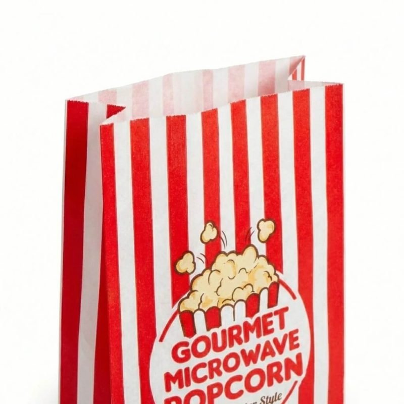 A microwavable popcorn bag showing the internal susceptor patch and freshly popped popcorn coming out.