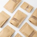 A brown kraft paper stand up pouch with window filled with granola and sealed with a zipper.
