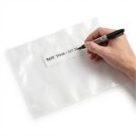 A clear embossed vacuum sealer bag with a writable white strip for labeling contents and dates being sealed.
