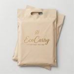 A blue poly mailer with handle featuring a custom white logo and being carried by its die-cut handle.