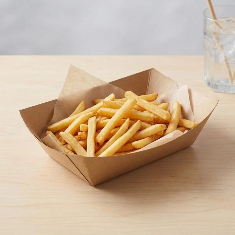 A disposable kraft paper boat tray filled with golden french fries and a hot dog.