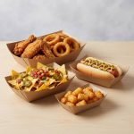 A disposable kraft paper boat tray filled with golden french fries and a hot dog.
