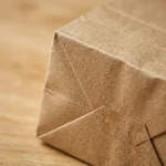 Soft kraft paper mailing bag material roll showing PET BOPP layer flexibility and durability
