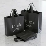 matte black plastic gift bags with handles showing prismatic rainbow effect on transparent soft BOPP base